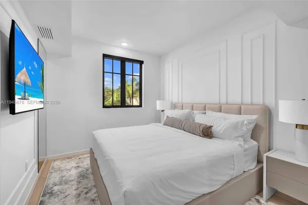 a bedroom with a bed and a painting on the wall