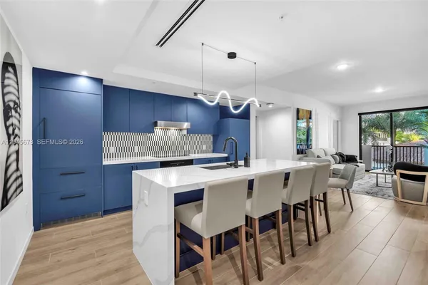 a kitchen with a dining table chairs and white cabinets