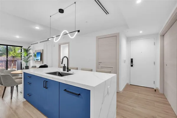 a kitchen with a sink a counter space and wooden floor