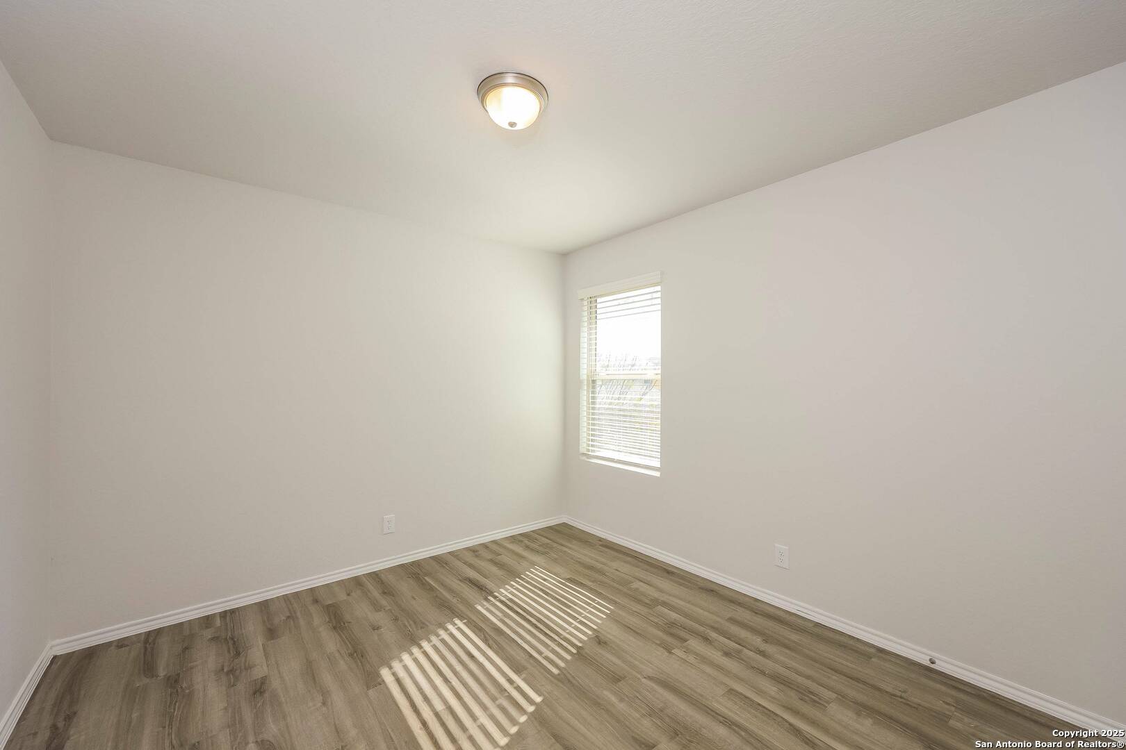 10328 Green Branch San Antonio, TX 78223 - Photo 13 of 16 an empty room with wooden floor and windows