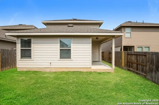 a view of house with backyard and furniture
