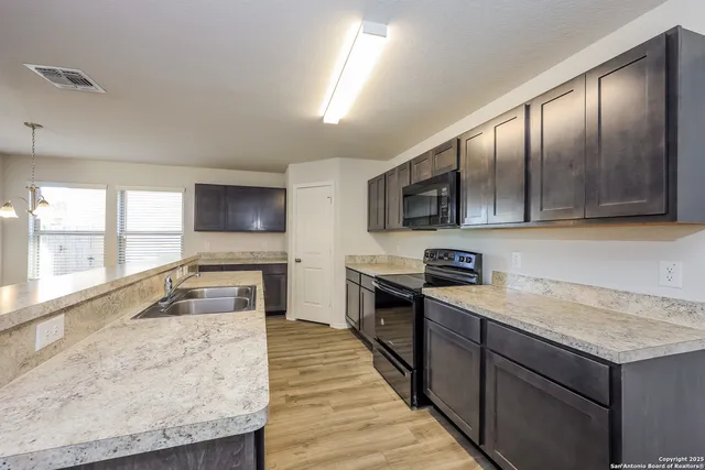 a kitchen with granite countertop stainless steel appliances and wooden cabinets