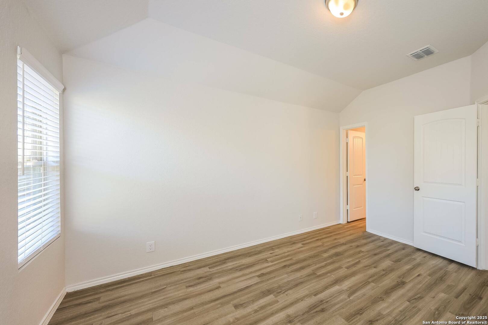 10328 Green Branch San Antonio, TX 78223 - Photo 10 of 16 a view of an empty room with wooden floor and a window