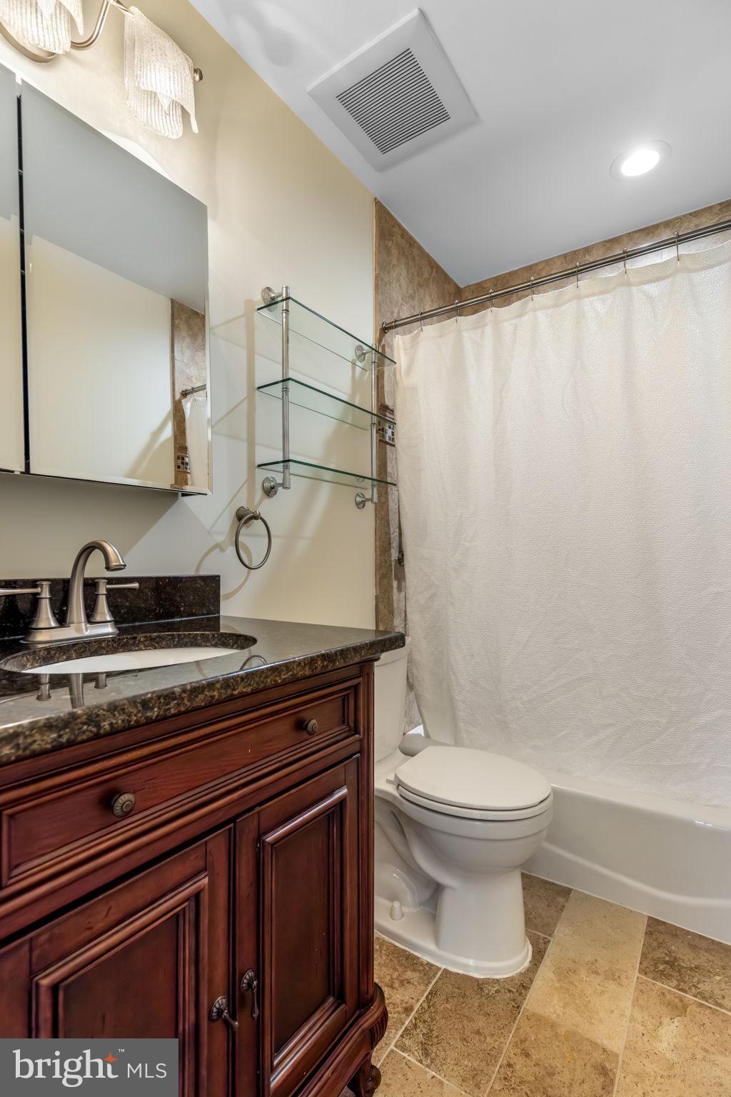 8371 Luce Court Springfield, VA 22153 - Photo 15 of 21 a bathroom with a granite countertop sink a toilet and a mirror