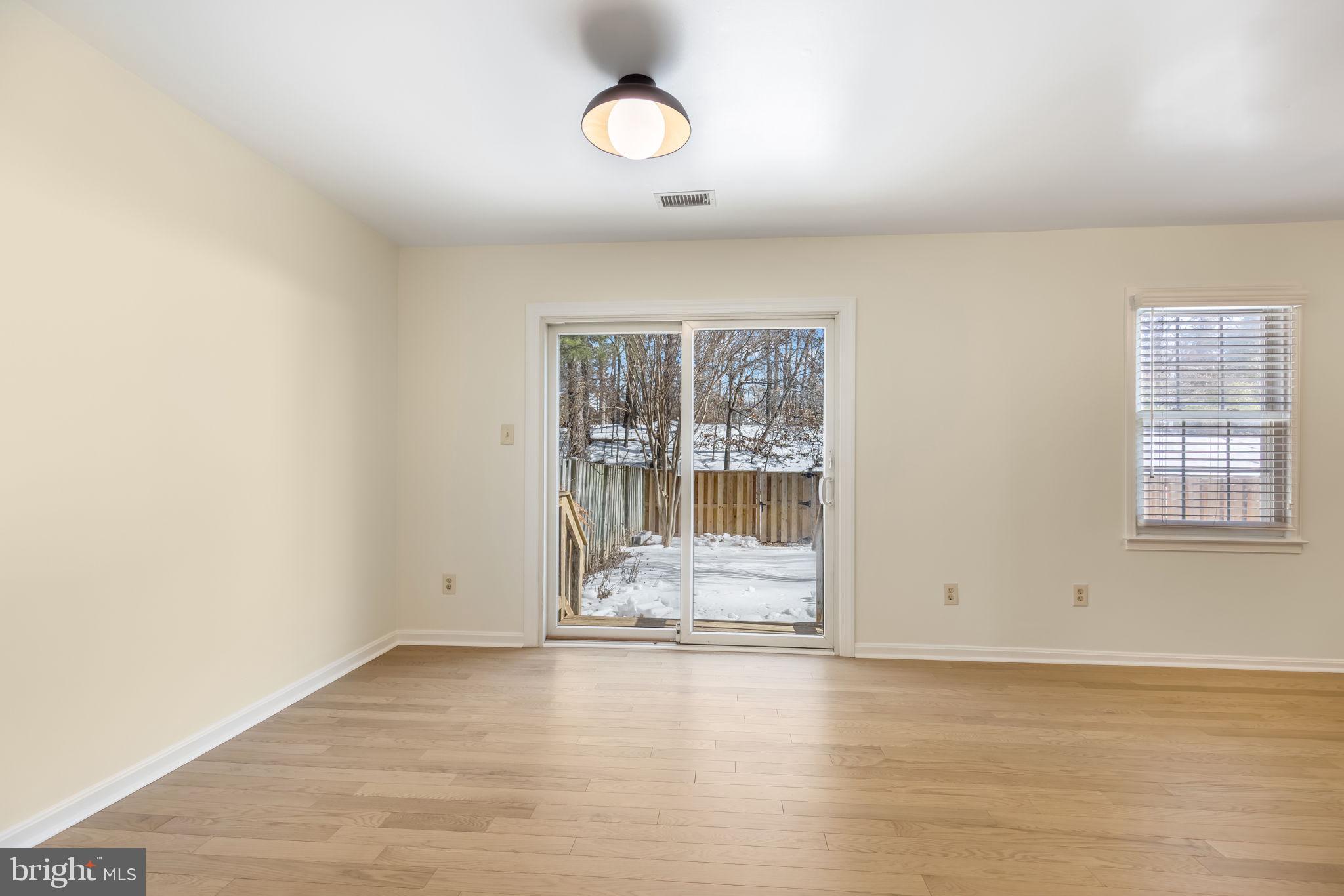 8371 Luce Court Springfield, VA 22153 - Photo 3 of 21 an empty room with wooden floor and windows