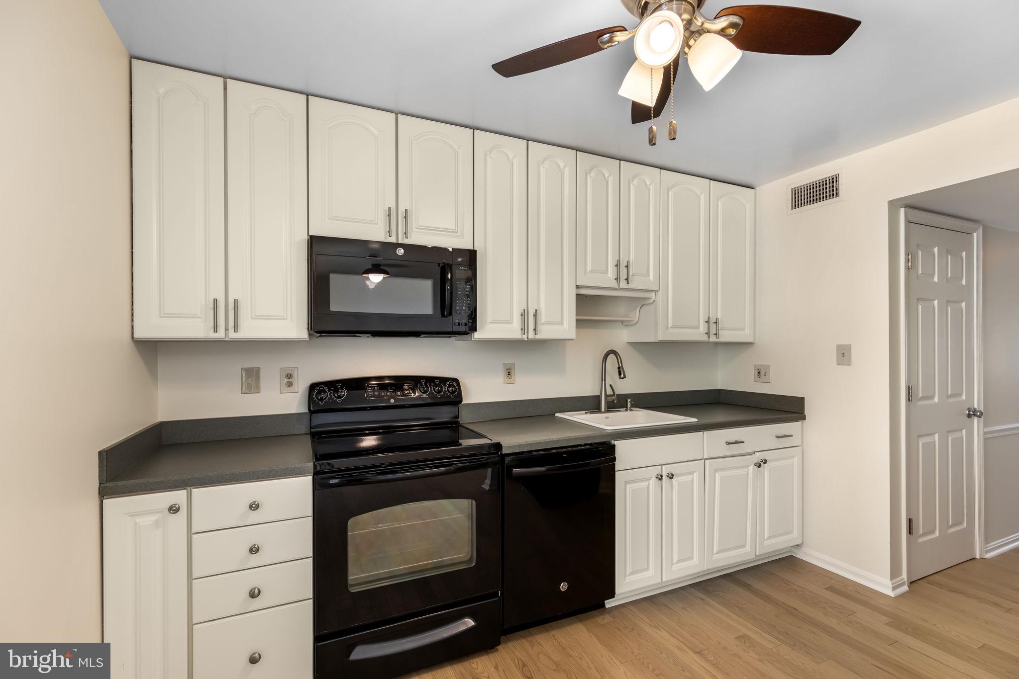 8371 Luce Court Springfield, VA 22153 - Photo 7 of 21 a kitchen with stainless steel appliances granite countertop a stove a microwave and cabinets