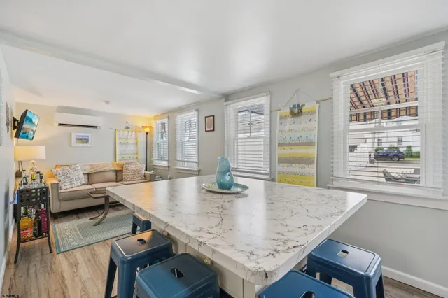 a kitchen with granite countertop kitchen island wooden floor white cabinets and stainless steel appliances