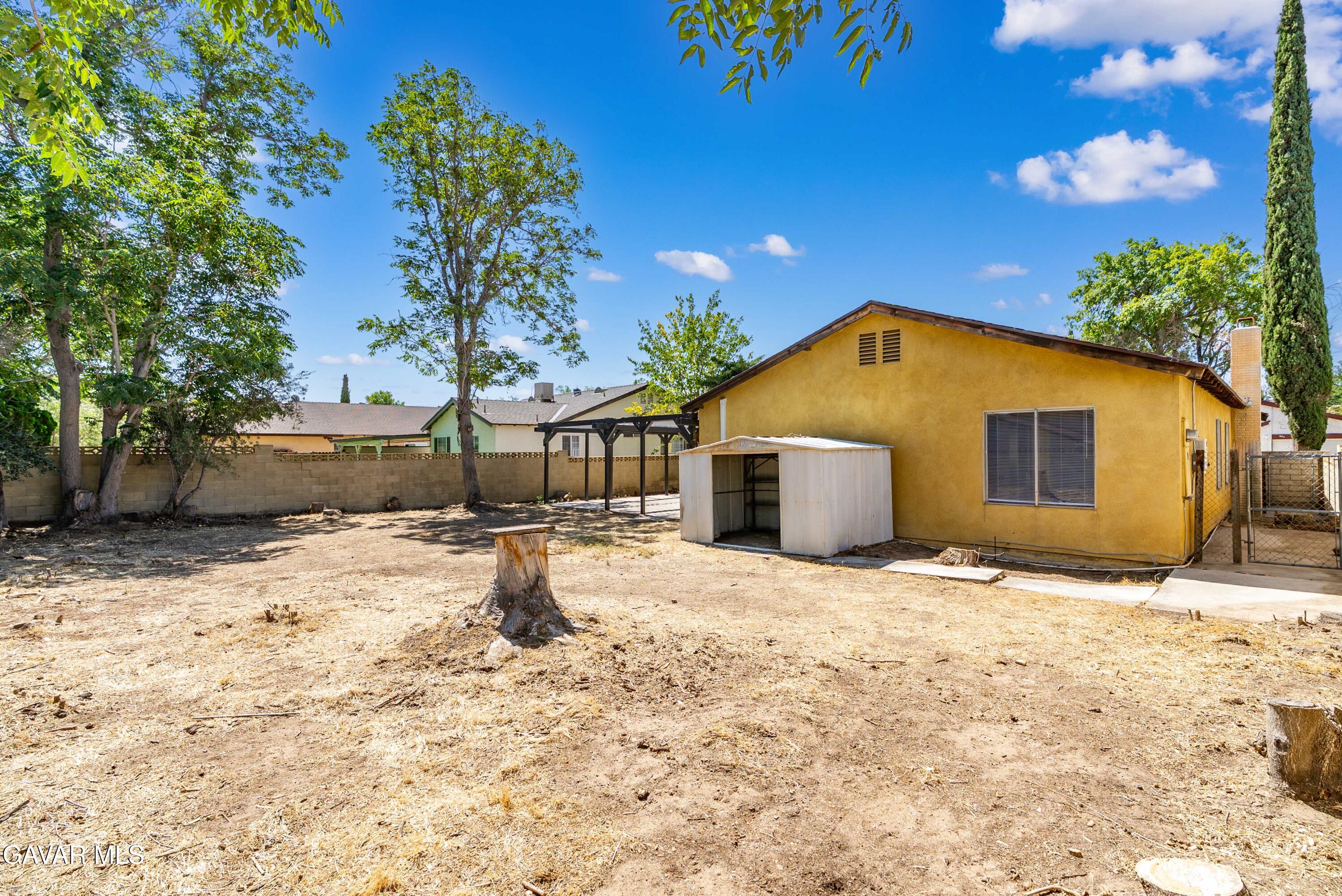1027 Caperton Street Lancaster, CA 93535 - Photo 29 of 30 a yellow house with trees in the background