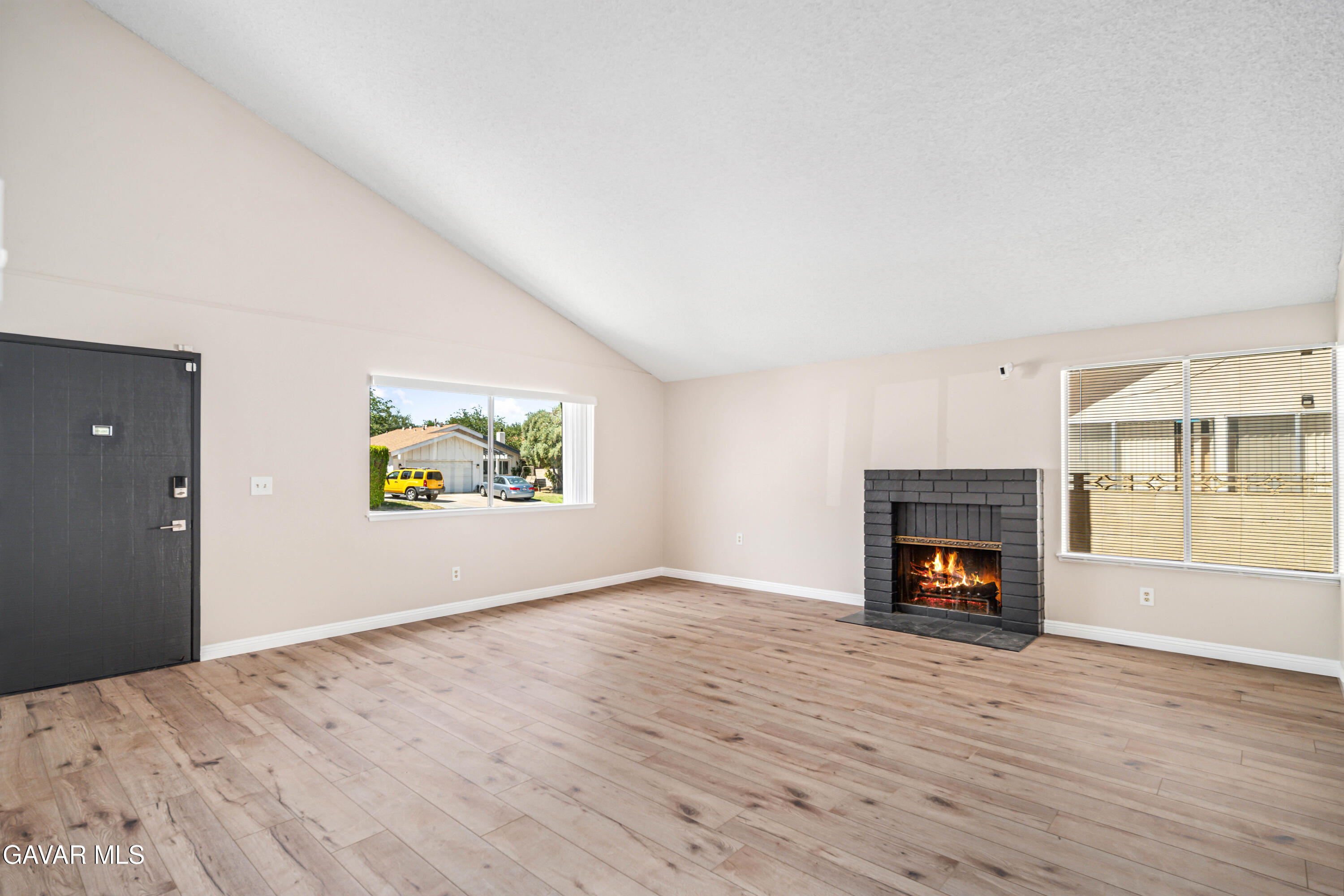 1027 Caperton Street Lancaster, CA 93535 - Photo 5 of 30 an empty room with a fireplace and wooden floor