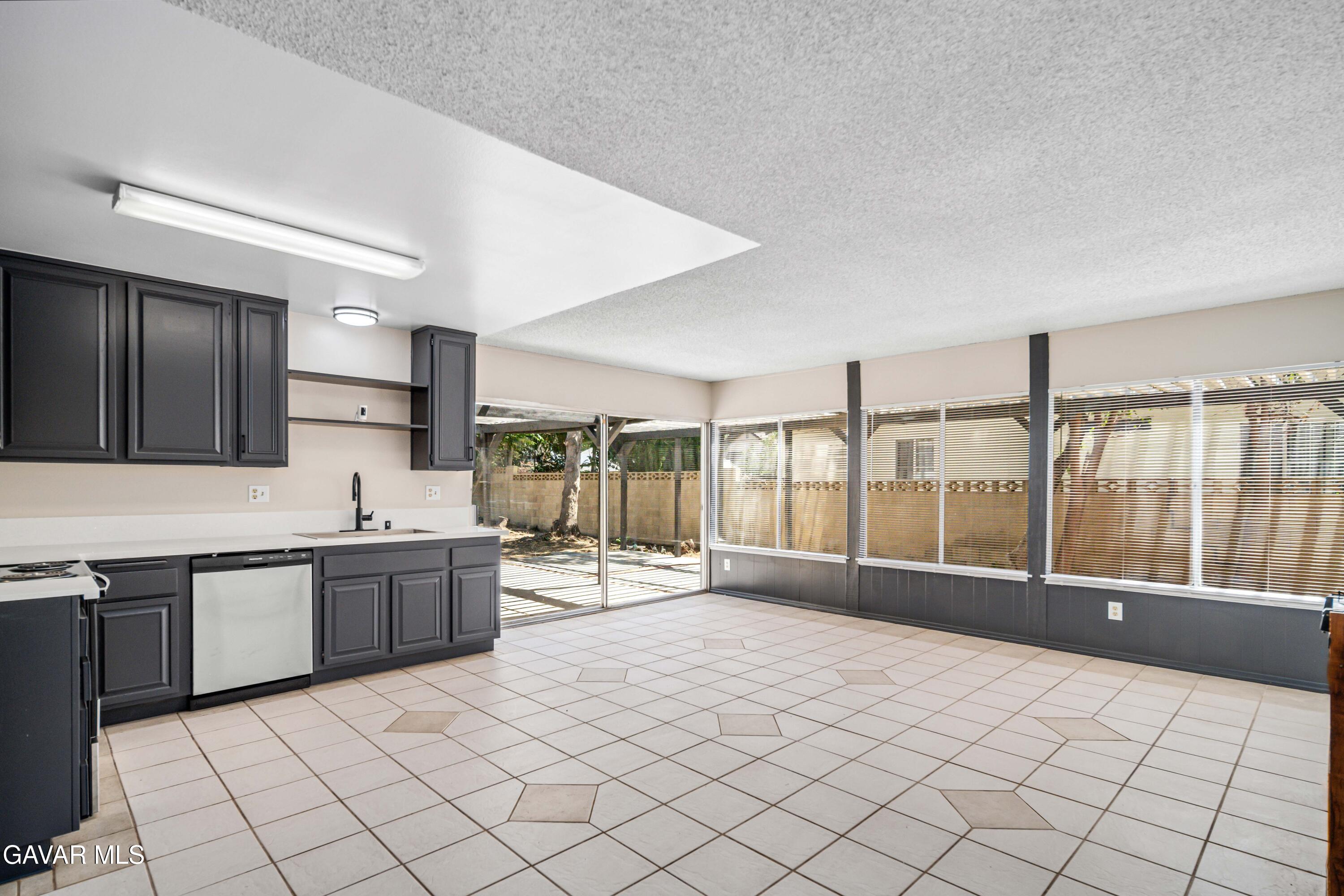 1027 Caperton Street Lancaster, CA 93535 - Photo 8 of 30 a large white kitchen with granite countertop a sink and cabinets