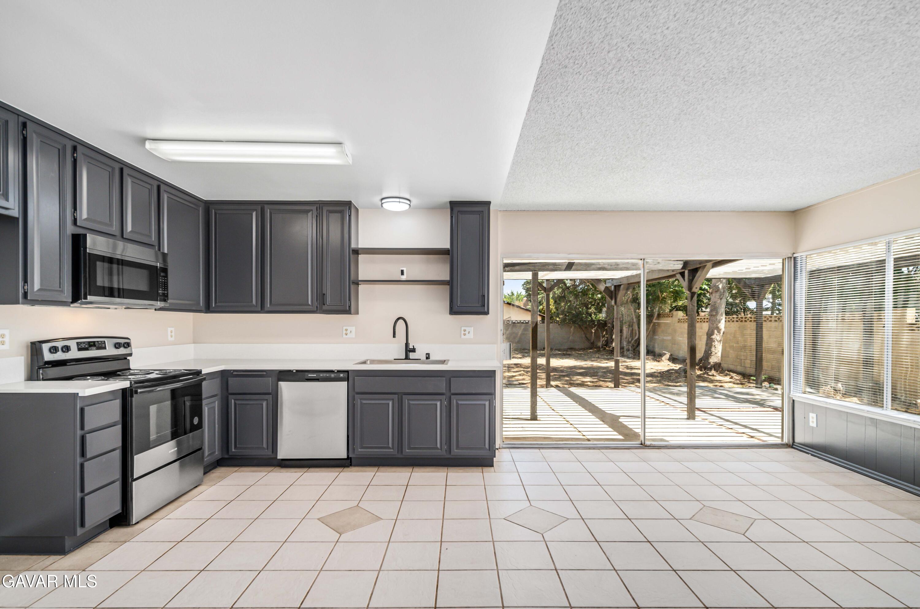 1027 Caperton Street Lancaster, CA 93535 - Photo 10 of 30 a kitchen with stainless steel appliances granite countertop a stove a sink and a microwave