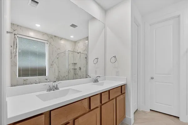 a bathroom with a double vanity sink mirror and shower
