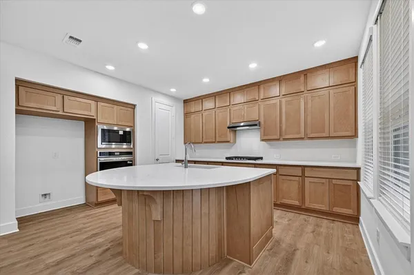 a large kitchen with stainless steel appliances granite countertop a sink and cabinets