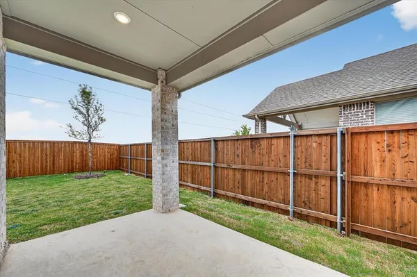 a view of a backyard with wooden fence