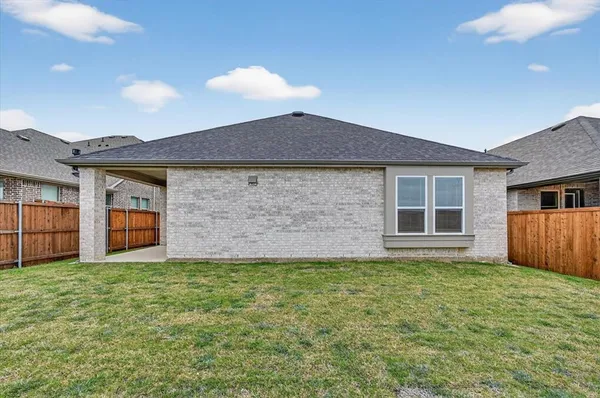a view of a house with a yard and a large tree