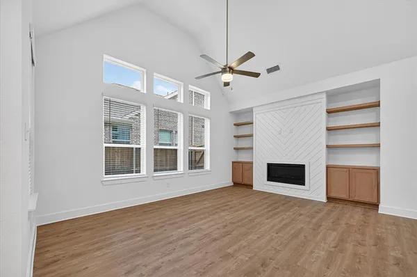 a view of an empty room with a fireplace and a window