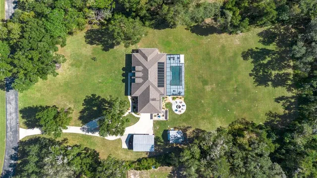 an aerial view of residential houses with outdoor space and trees