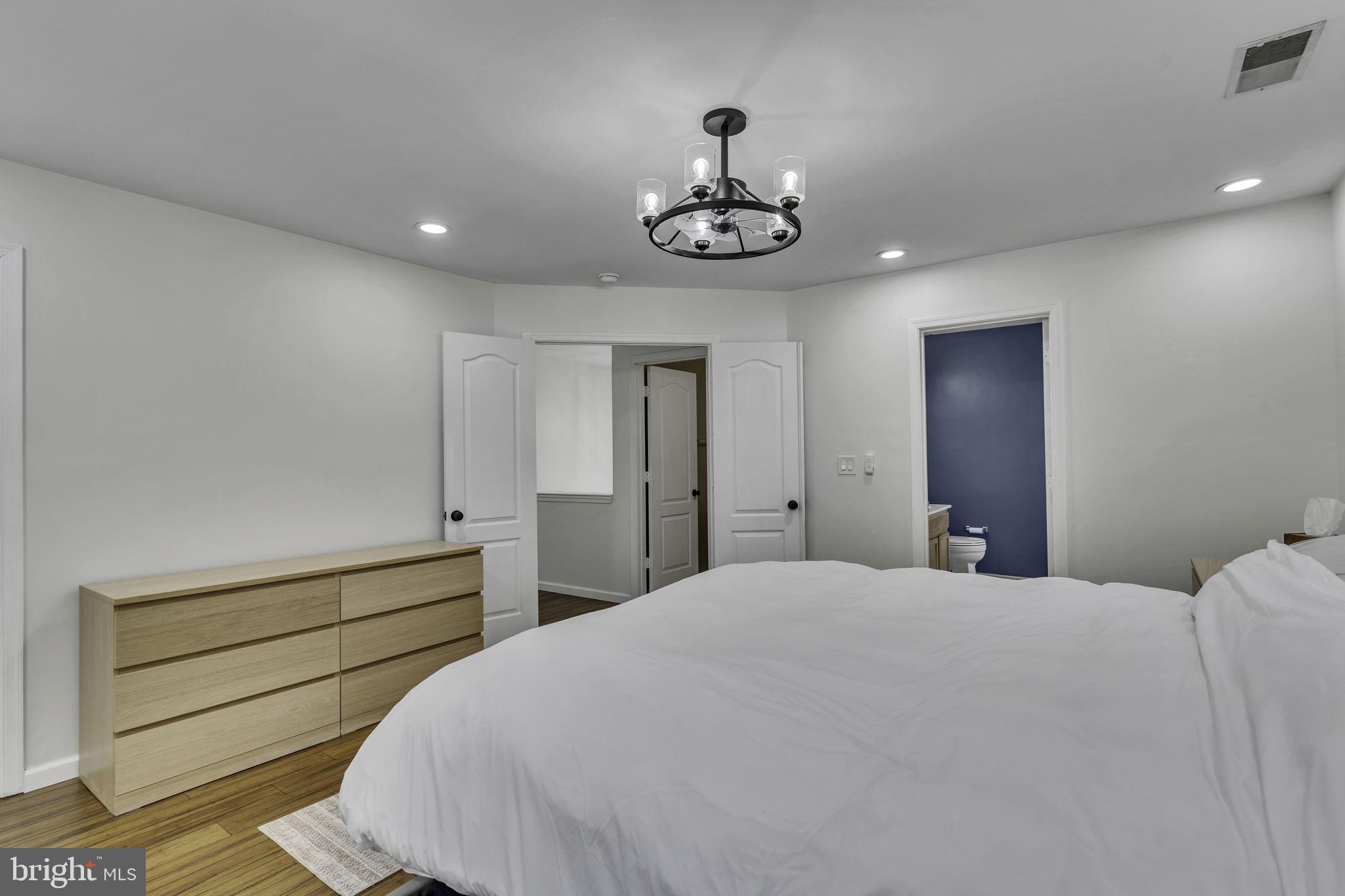 6546 Cornell Road Bryans Road, MD 20616 - Photo 24 of 35 a bedroom with a bed and a chandelier