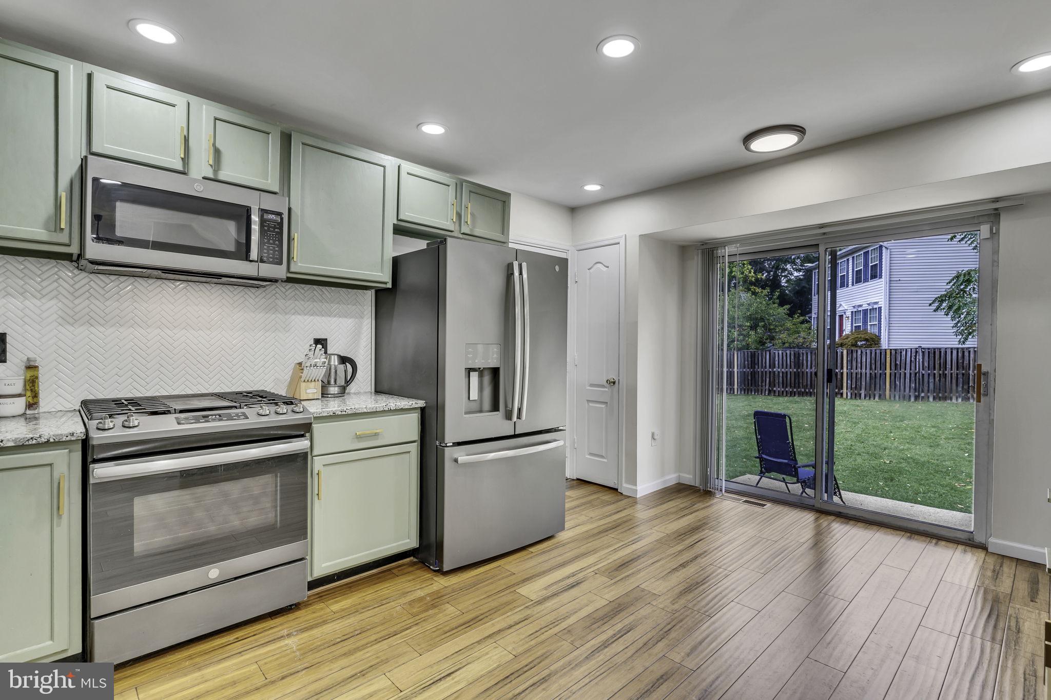 6546 Cornell Road Bryans Road, MD 20616 - Photo 8 of 35 a kitchen with stainless steel appliances a stove a refrigerator cabinets and a wooden floor