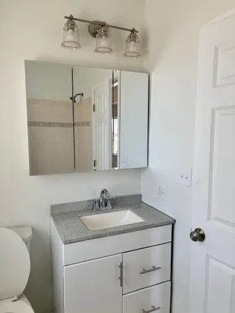 a bathroom with a sink toilet and mirror