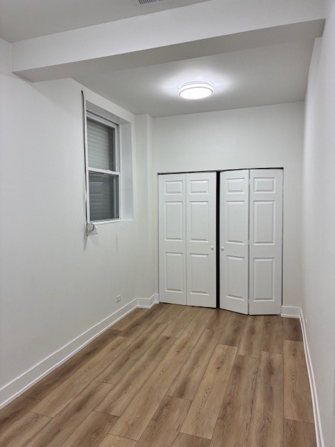 8010 South Ridgeland Avenue, Unit 1D Chicago, IL 60617 - Photo 19 of 28 a view of empty room with wooden floor and fan