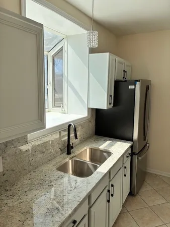 a kitchen with stainless steel appliances granite countertop a sink refrigerator and microwave