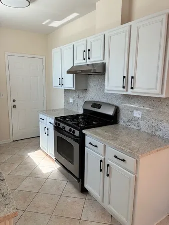 a kitchen with white cabinets and appliances