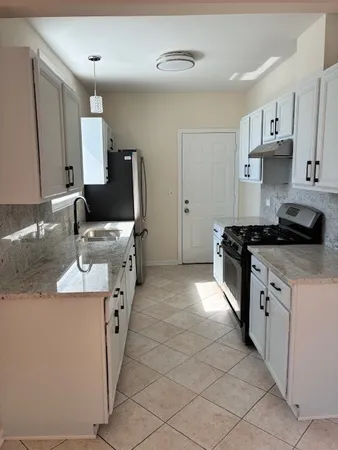 a kitchen with stainless steel appliances a sink stove and cabinets