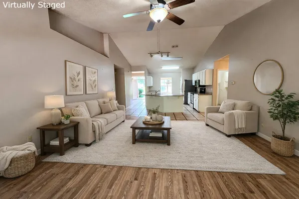 a living room with furniture and a wooden floor