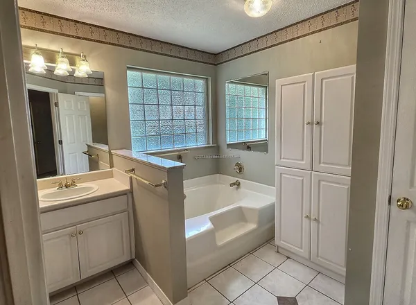 a bathroom with a tub sink and mirror