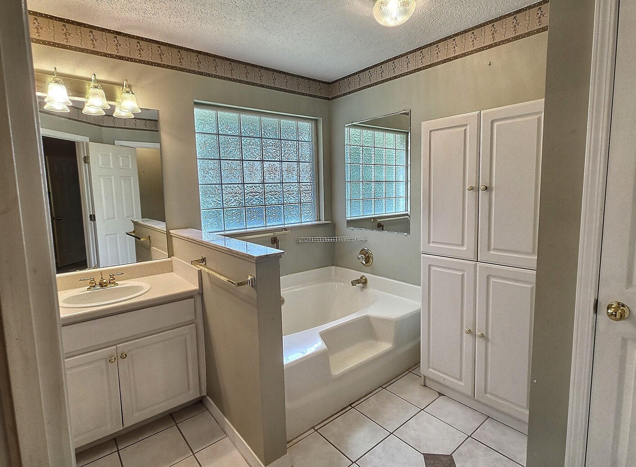 4868 Orlimar Street Crestview, FL 32536 - Photo 19 of 25 a bathroom with a tub sink and mirror