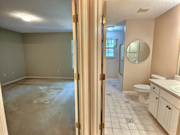 a bathroom with a toilet a sink and mirror