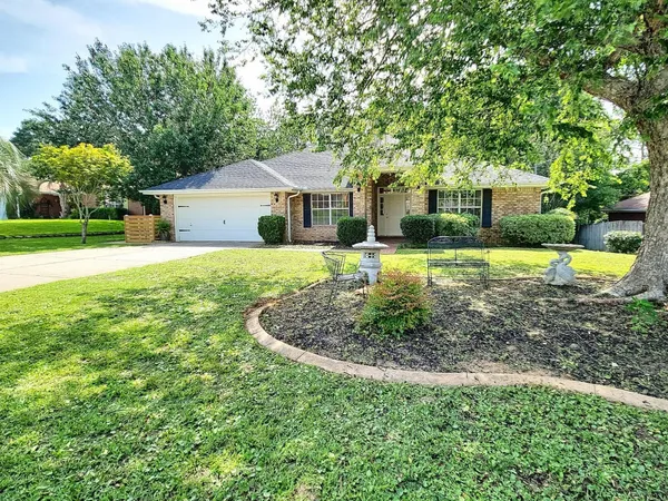 a front view of a house with a yard and trees