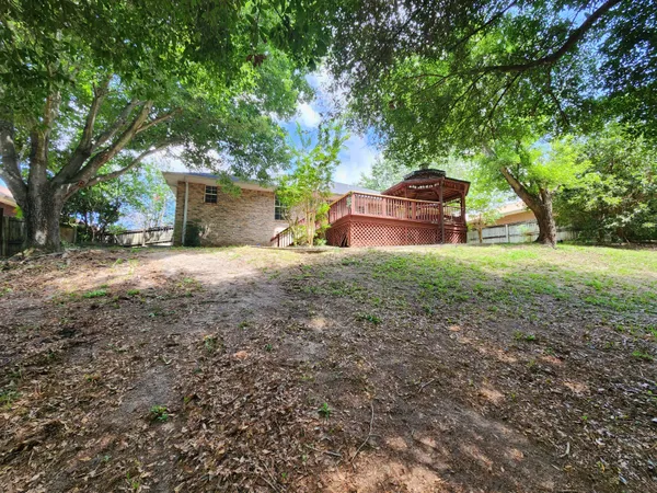 a backyard of a house with table and chairs