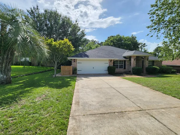 a front view of a house with a yard and trees
