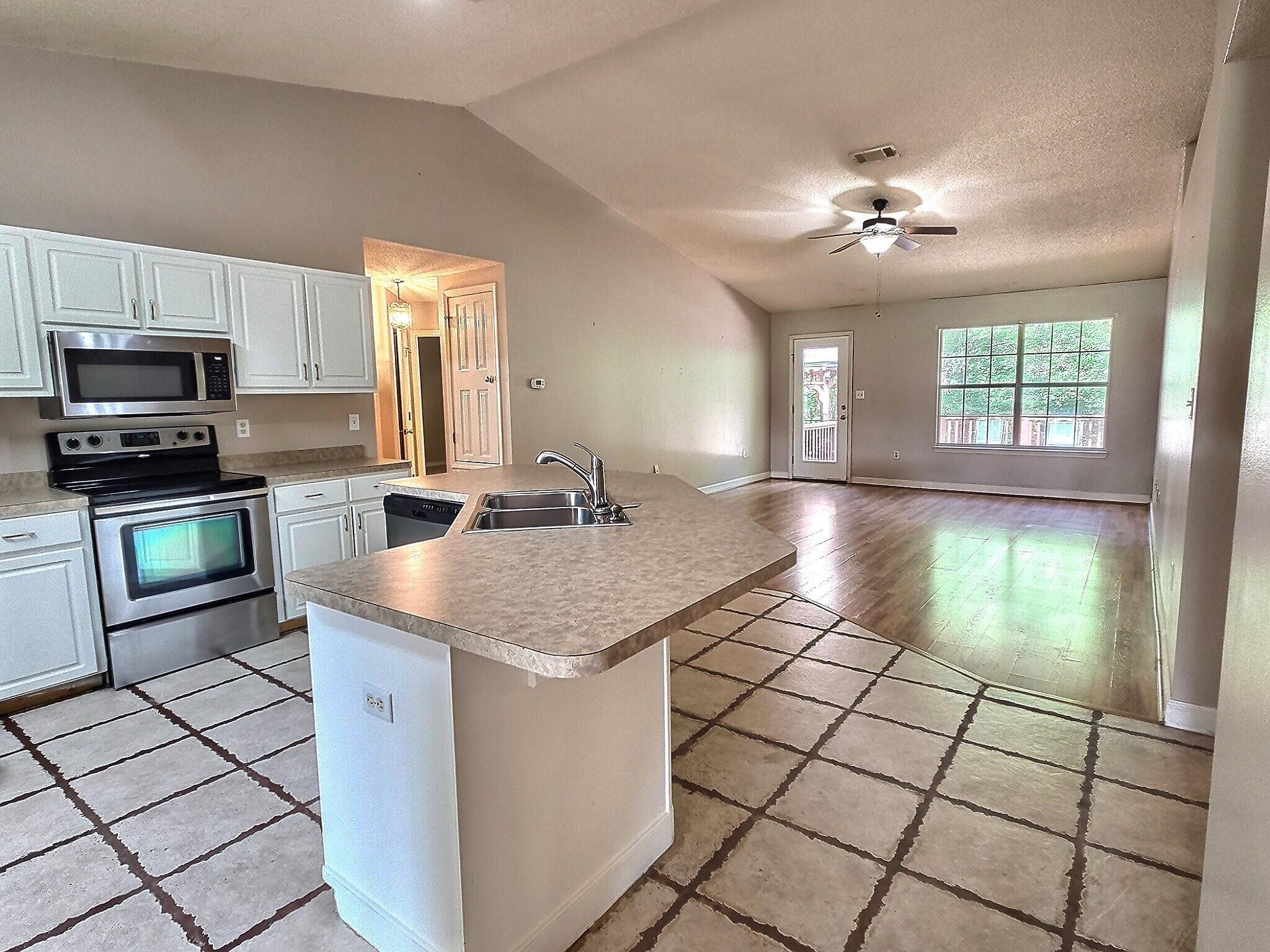 4868 Orlimar Street Crestview, FL 32536 - Photo 10 of 25 a kitchen with stainless steel appliances granite countertop a stove a sink and a microwave