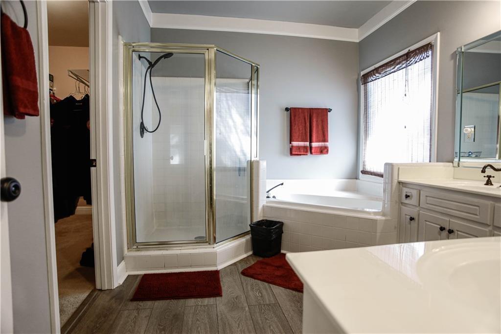3875 Spring Manor Court Loganville, GA 30052 - Photo 21 of 23 a bathroom with a tub shower sink and mirror