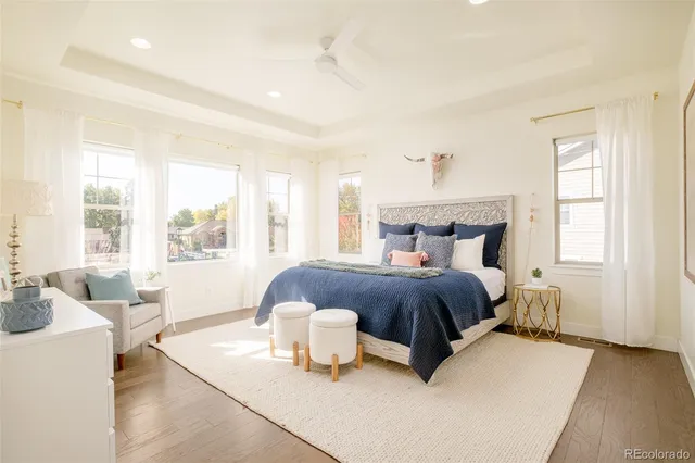 a bedroom with a bed and large windows