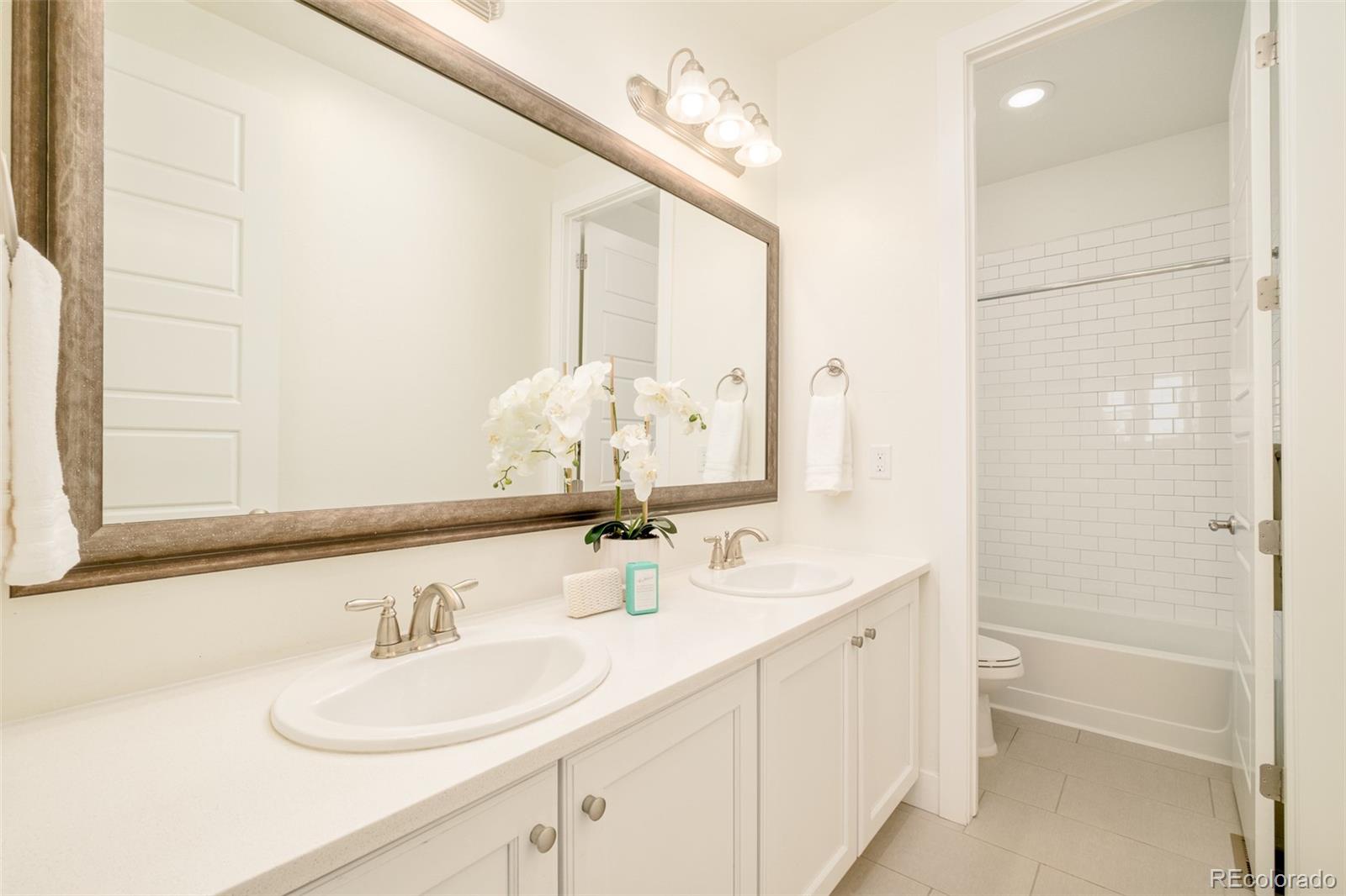 11880 West 38th Place Wheat Ridge, CO 80033 - Photo 23 of 30 a bathroom with a double vanity sink mirror and a