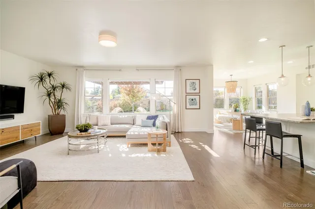 a living room with furniture wooden floor and a flat screen tv