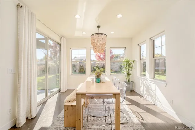 a dining room with wooden floor a chandelier
