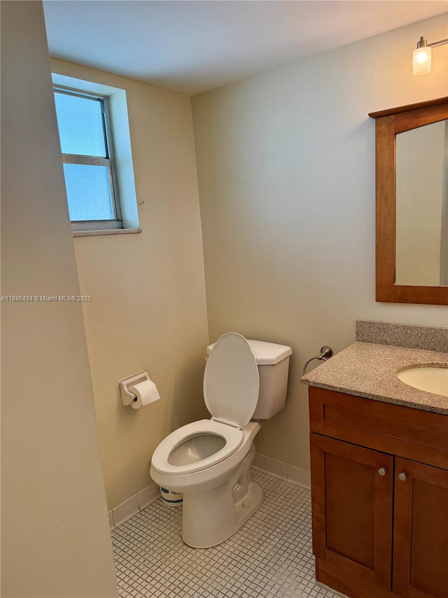 9810 Marina Boulevard, Unit 1124 Boca Raton, FL 33428 - Photo 11 of 15 a white toilet sitting next to a bathroom sink