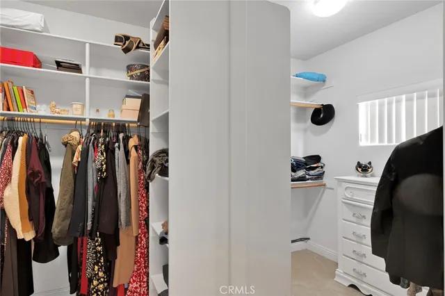 a view of walk in closet with clothes and shoes