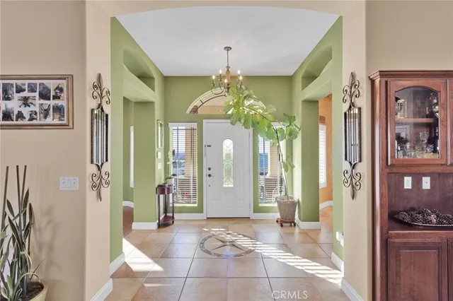 a view of a hallway with a chandelier dining table and chairs