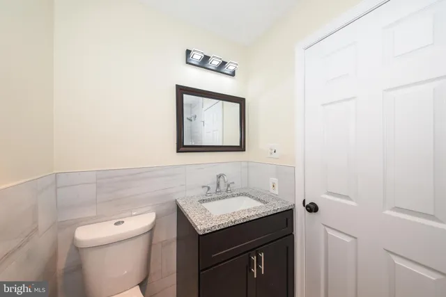 a bathroom with a toilet a sink and mirror