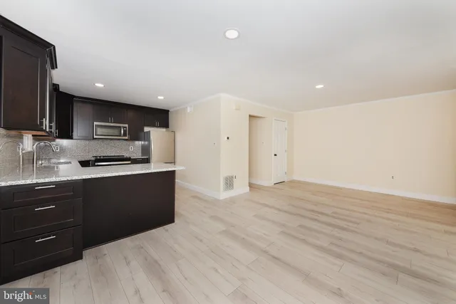 a kitchen with stainless steel appliances granite countertop a refrigerator and a stove top oven