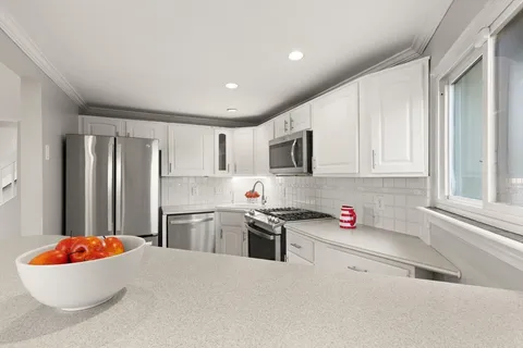 a kitchen with stainless steel appliances granite countertop a refrigerator sink and stove top oven