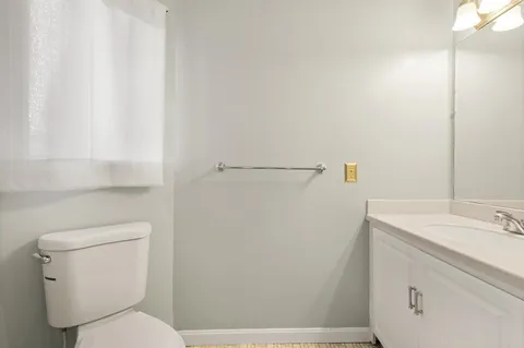 a bathroom with a toilet sink and vanity