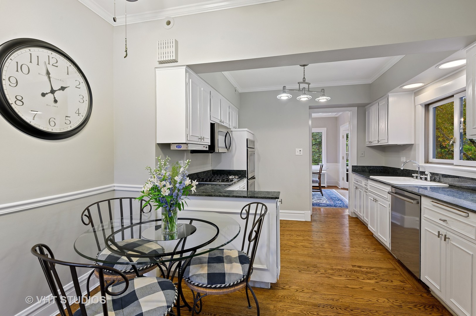 304 Cumnor Road Kenilworth, IL 60043 - Photo 19 of 40 a view of a kitchen with kitchen island a table and a clock