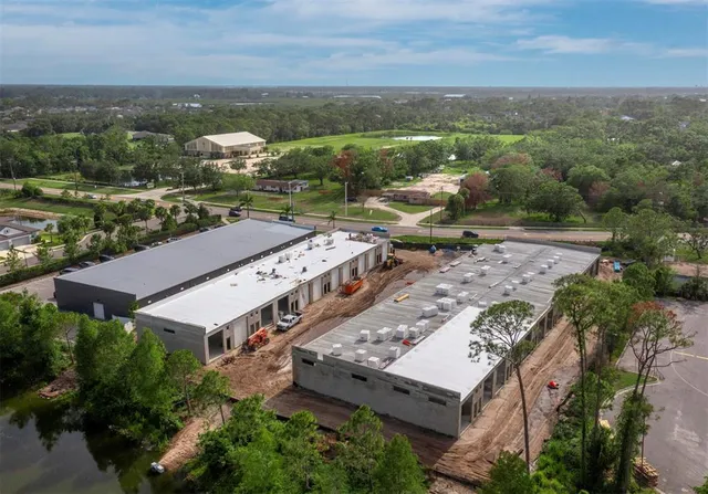 an aerial view of a house with a garden and lake view